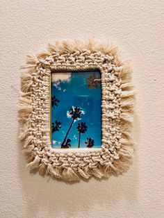 a photo frame hanging on the wall with palm trees in it