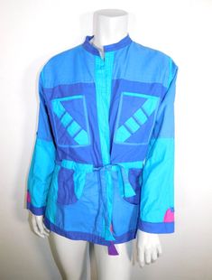 This great 80s jacket is like getting two jackets in one! It's blue on one side and purple and pink on the other. Both sides feature a tie belt. The jacket is an open front style. It has patch pockets on both sides. There are tabs in the sleeves so you can roll them up and show off the contrast color of the other side of the jacket. So basically you get about 4 looks in one-what a deal! Jacket has no designer labels that I could find but there is a small size tag sewn to one pocket that says M. 90s Patchwork Blue Outerwear, 90s Blue Patchwork Outerwear, 90s Style Blue Patchwork Outerwear, Designer Labels, 80s Jacket, Types Of Hats, Designer Label, Sewing Tags, Pink M