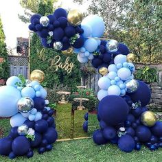 blue and gold balloon arch for a baby's first birthday party in the backyard