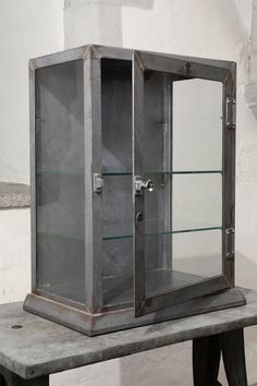 a metal cabinet sitting on top of a cement bench