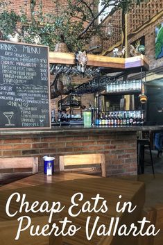 the inside of a restaurant with chalkboard menus on the wall and wooden tables