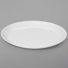 an empty white plate on a gray background