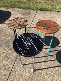 three wooden tables sitting on top of a sidewalk