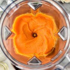 a blender filled with orange liquid on top of a table