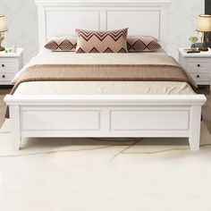 a white bed with two nightstands next to it