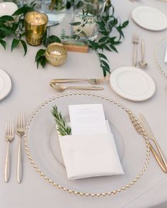 a table set with place settings, silverware and napkins for an elegant dinner