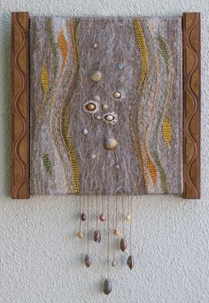 a wall hanging on the side of a building with rocks and shells attached to it