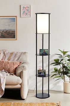 a living room filled with furniture and a lamp on top of a shelf next to a couch