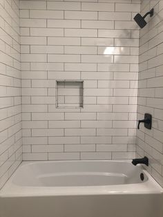 a white bath tub sitting inside of a bathroom next to a shower head and faucet