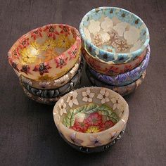 four bowls sitting on top of a table next to each other with flowers painted on them