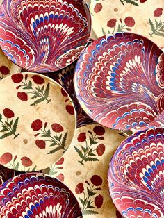 many plates with designs on them are stacked up in the shape of flowers and leaves