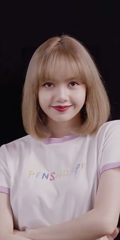 a woman with blonde hair wearing a white t - shirt and posing for the camera