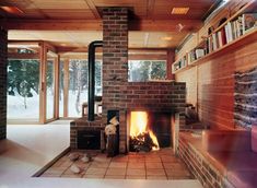 a living room filled with furniture and a fire place in front of a window covered in snow