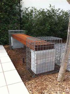 a caged area with a wooden bench in the middle and two metal cages around it