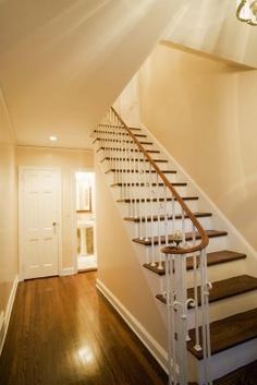 a white staircase with wooden handrails in a home