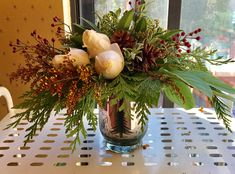 a vase filled with flowers sitting on top of a white table next to a window