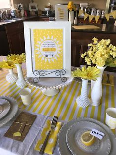 a yellow and white table setting with flowers in vases, plates and napkins