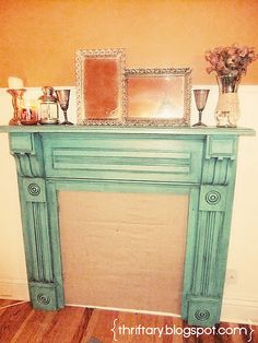 an old fireplace with candles and pictures on it