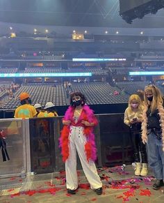 two women in costumes standing at the end of a baseball field with confetti all over them