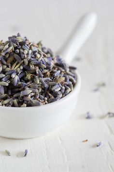 a white bowl filled with lavender seeds on top of a table