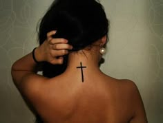 a woman with a cross tattoo on her back