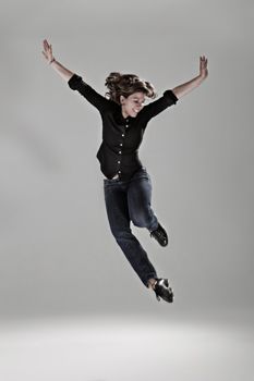 a woman is jumping in the air with her arms outstretched and legs spread wide open