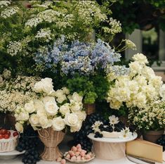 a table topped with lots of different types of flowers and fruit on top of it