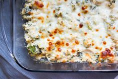 a casserole dish with cheese and broccoli in it on a table