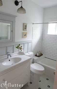 a white bathroom with a sink, toilet and bathtub