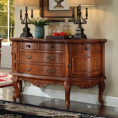 a wooden dresser with two lamps on top of it