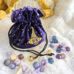 This wizard multi pocket dice bag is made with starry purple velvet and matching plush fabric. It is soft to the touch and will keep your dice nice and cozy. The embroidered design on the front features a large wizard hat with a D20 underneath it. The bag has strong cord drawstrings accented with golden sun charms at the ends.Inner bag space is about 9 x 4.5 inches, plenty of room for several sets of dice, there are 6 inner pockets that will hold 3 to 4 standard dice sets and 1 large middle pock Wizard Dice, Wizard Hat, Ritual Tools, Golden Sun, Dice Bag, Plush Fabric, Purple Velvet, Velvet Bag, Embroidered Design