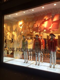 mannequins are displayed in the window of a clothing store