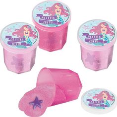 three pink plastic containers with little mermaids on the lids and one has a starfish in it