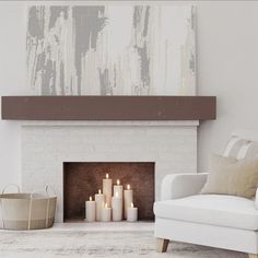 a living room with a white couch and some candles in front of the fire place