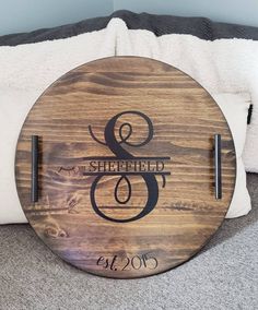 a wooden sign with the word and date engraved on it, sitting on top of a bed