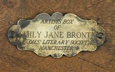 a plaque on the side of a wooden table that reads artists box of lily jane bronte