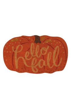 an orange pumpkin with the word fall spelled on it's front door mat that says,