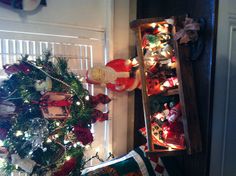 two wooden boxes filled with christmas decorations next to a window