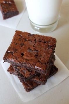 two pieces of brownie sitting on top of a white plate next to a cup