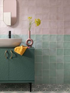 a bathroom with green tiles and a sink in the corner, next to a mirror