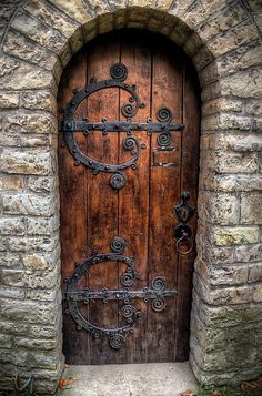 an old wooden door with iron work on it