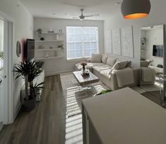 a living room filled with furniture next to a kitchen