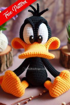 a crocheted black and white duck sitting on top of a table