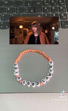 a woman's face is shown behind a beaded bracelet with words on it