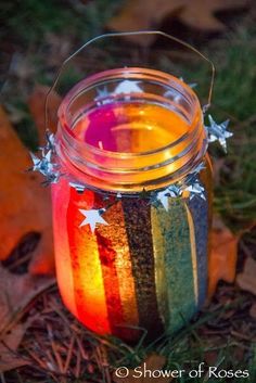 a jar filled with rainbow colored liquid sitting on the ground