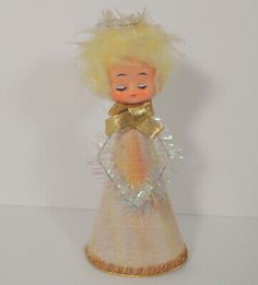 an old doll with blonde hair wearing a white dress