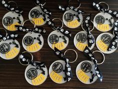 twelve personalized key chains with monogrammed letters and flowers on them, all decorated in black and yellow