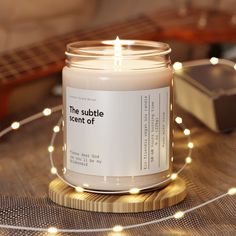 a candle sitting on top of a table next to a string of lights and a guitar