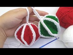 crocheted ornaments are being held by someone's hand with yarn in the background