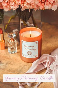 a candle and some pink flowers on a table